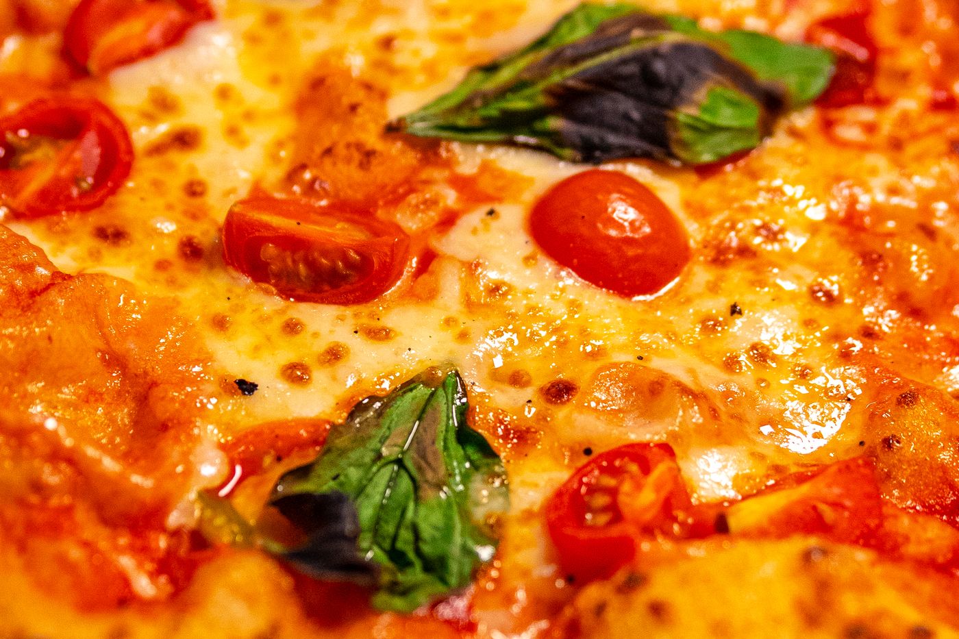 Detalle de la mozzarella fundida y el tomate cherry de la pizza margherita